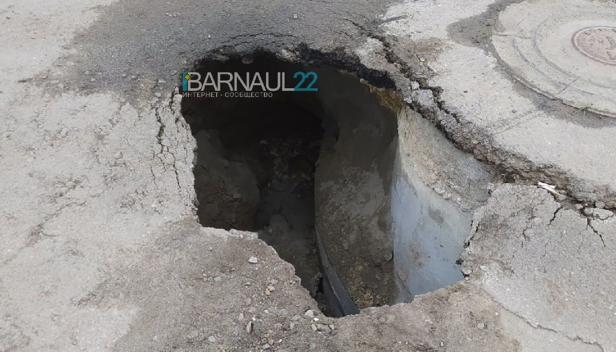 Рос яма. В Барнауле провалился асфальт. Провал грунта у люка. Во дворе образовалась яма в возле канализации. Трубы в Барнауле возле ямы.