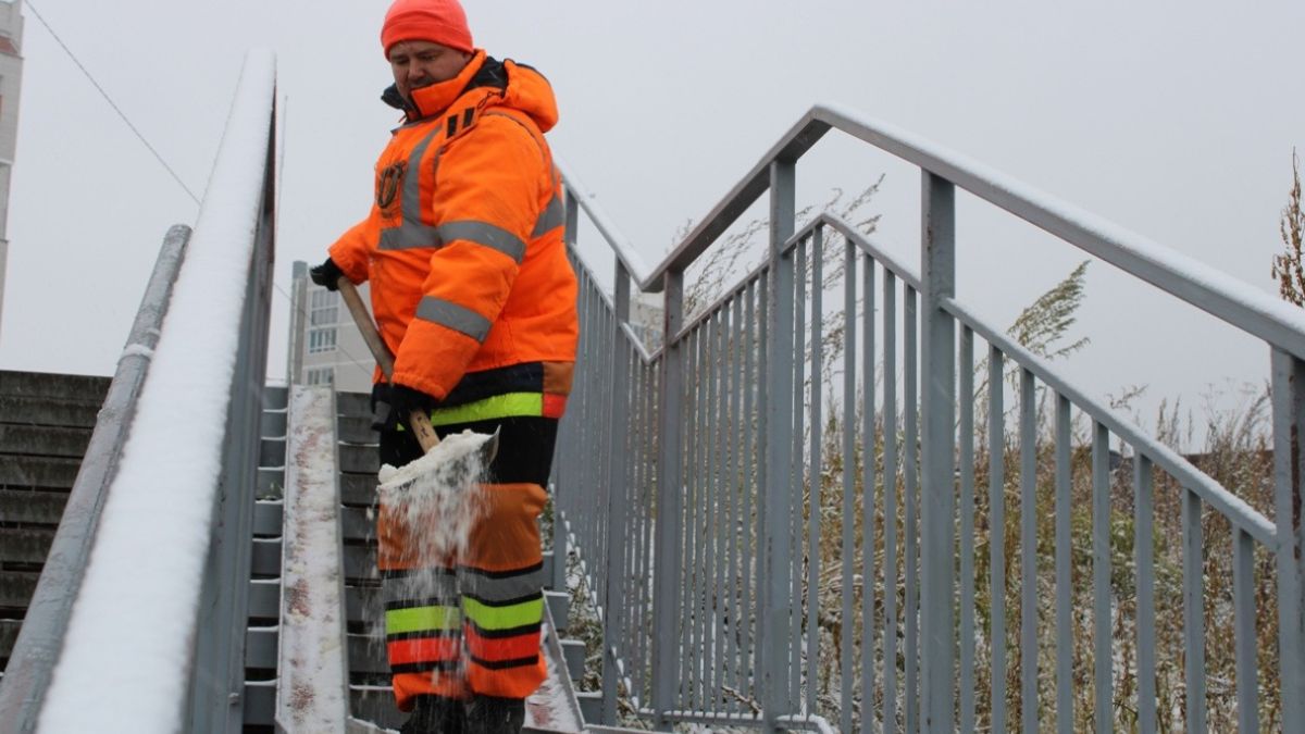 Спецбригада чистит от снега пешеходный путь в районе моста на проспекте Ленина