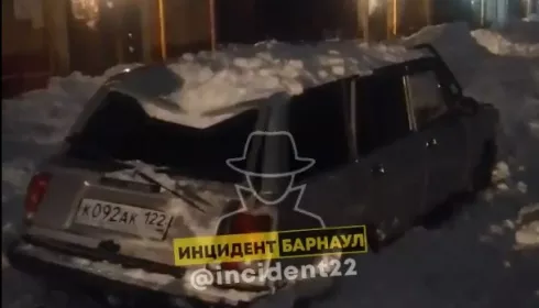 В Барнауле куча снега рухнула на припаркованную машину и продавила крышу