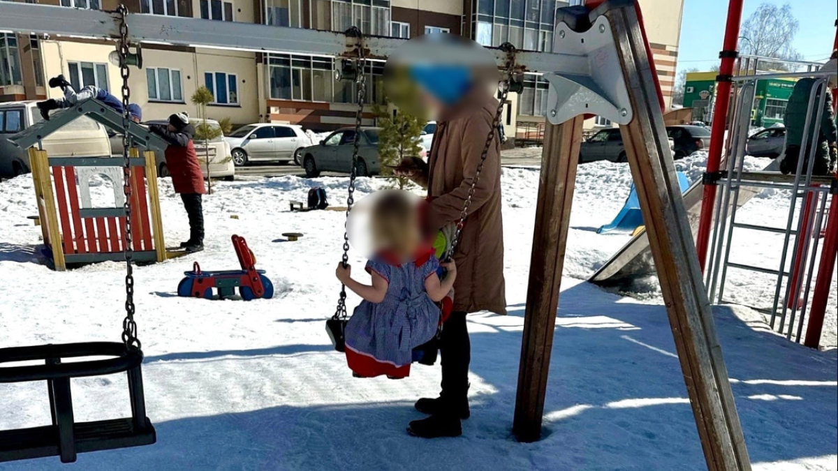 Девочка в платье на детской площадке в Новосибирске