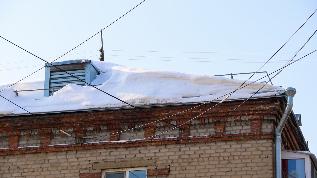 Снег и сосульки на крышах в Барнауле