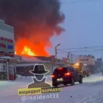 В Барнауле открытым огнем полыхает здание в районе Теплого рынка