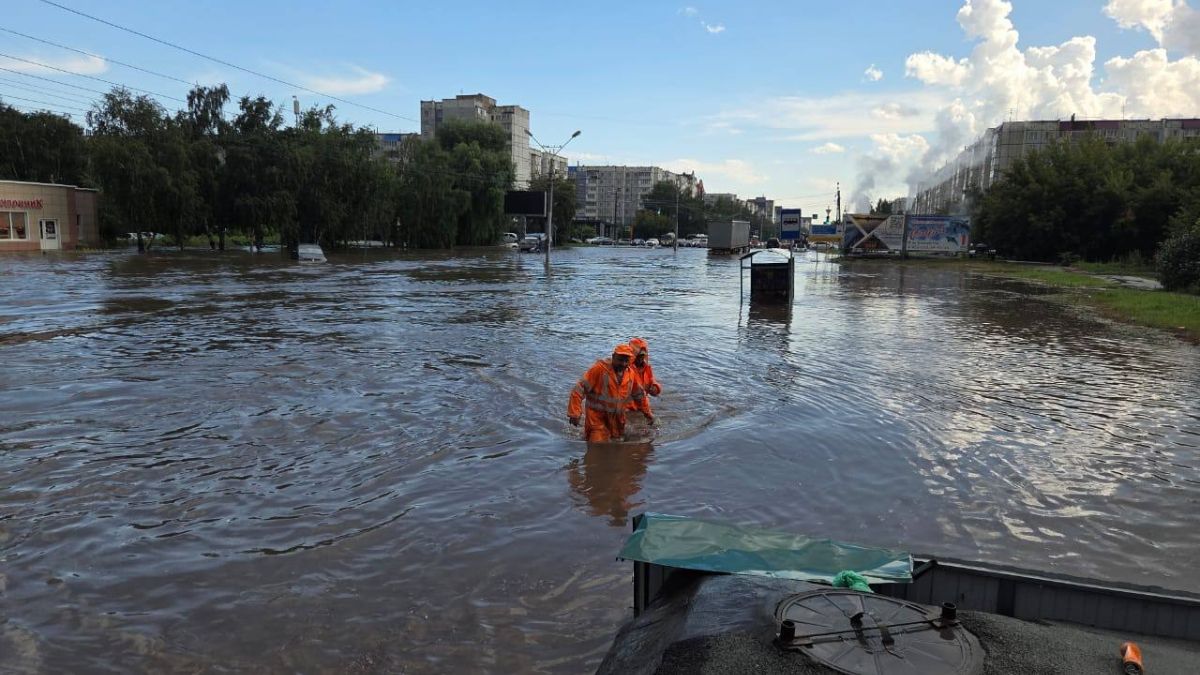 Дорожные службы очищают ливневки во время сильного дождя в Барнауле