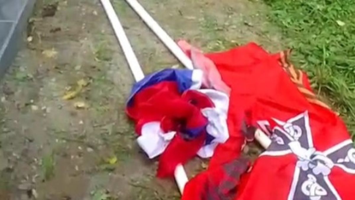 Поврежденные флаги на кладбище в селе Зудилово
