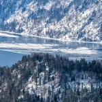 Белые поля с паутиной трещин: Телецкое озеро частично затянуло льдом. Фото