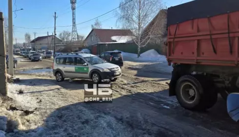 Рабочие чистят ливневку и заледенелую дорогу на улице Кутузова в Барнауле