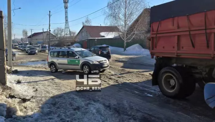 Рабочие чистят ливневку и заледенелую дорогу на улице Кутузова в Барнауле