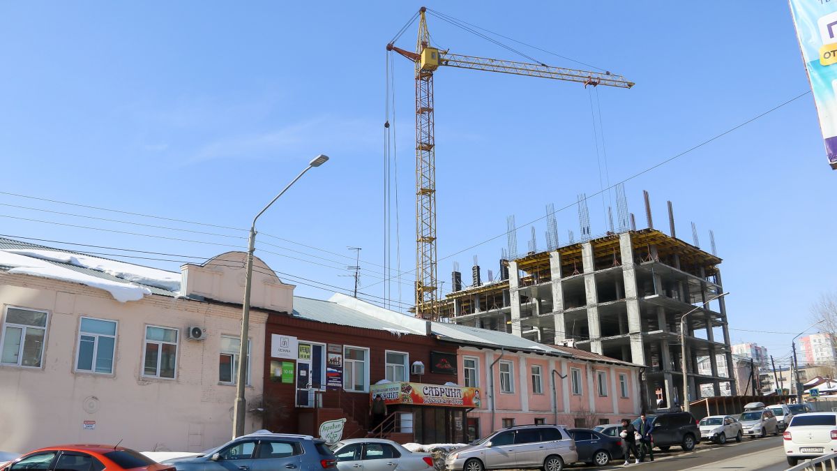 Проспект Комсомольский. Двухэтажное здание с розовыми фасадами у стройки – дом ул. Никитина, 41а