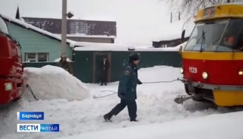 Трамвай вытянул увязший в сугробе КамАЗ спасателей в Барнауле